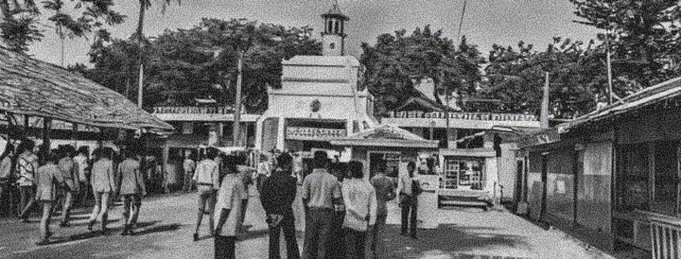 Suasana halaman pesantren dengan orang berkumpul di depan bangunan bermenara